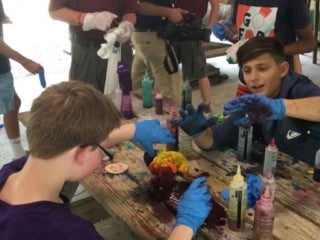 A group of campers wearing gloves and tie-dying t-shirts.