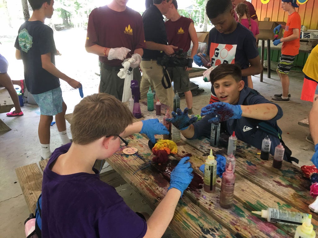 A group of campers wearing gloves and tie-dying t-shirts.