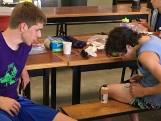 A male camper looks a device stuck to his thigh.